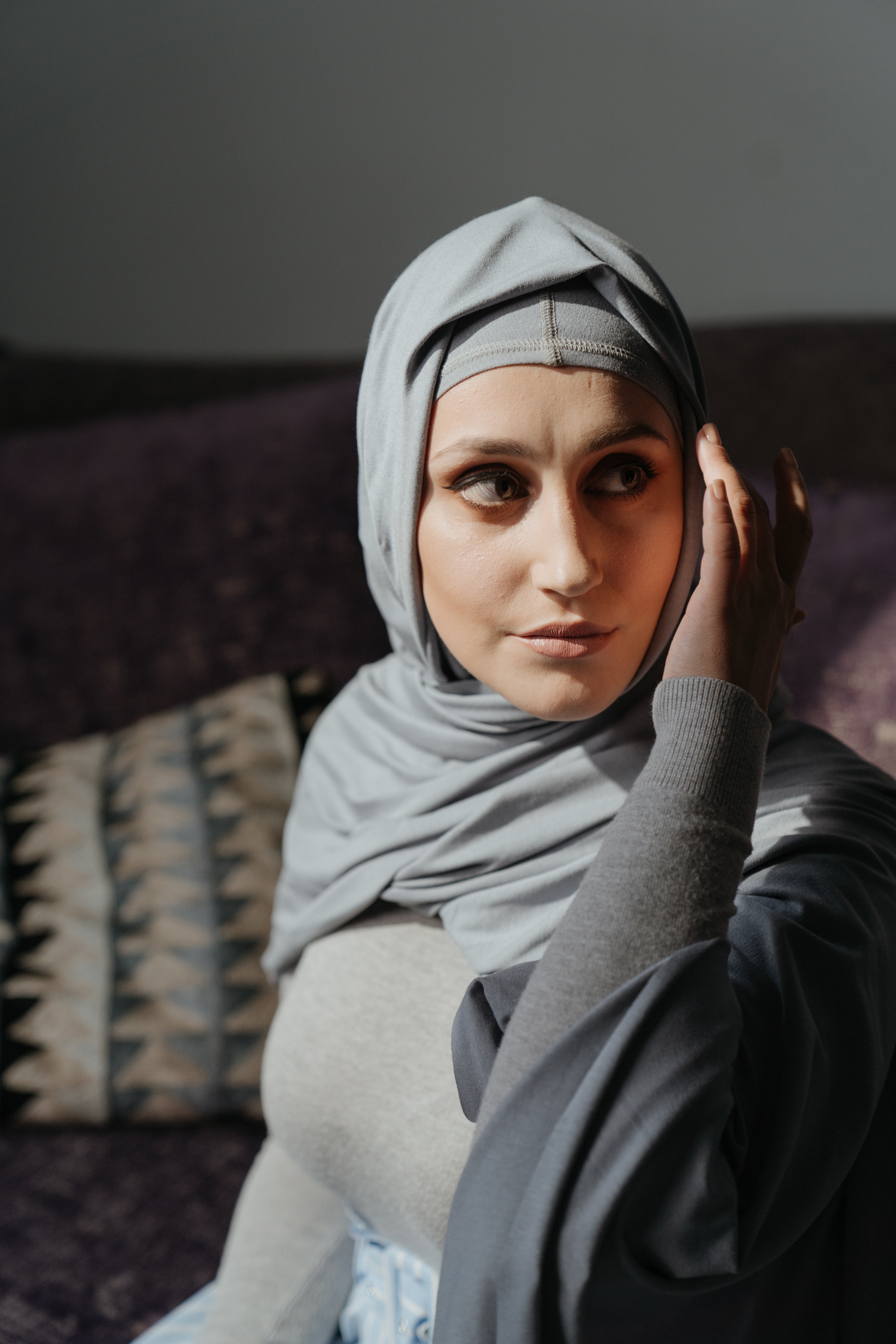 woman in gray hijab sitting on couch 4620864